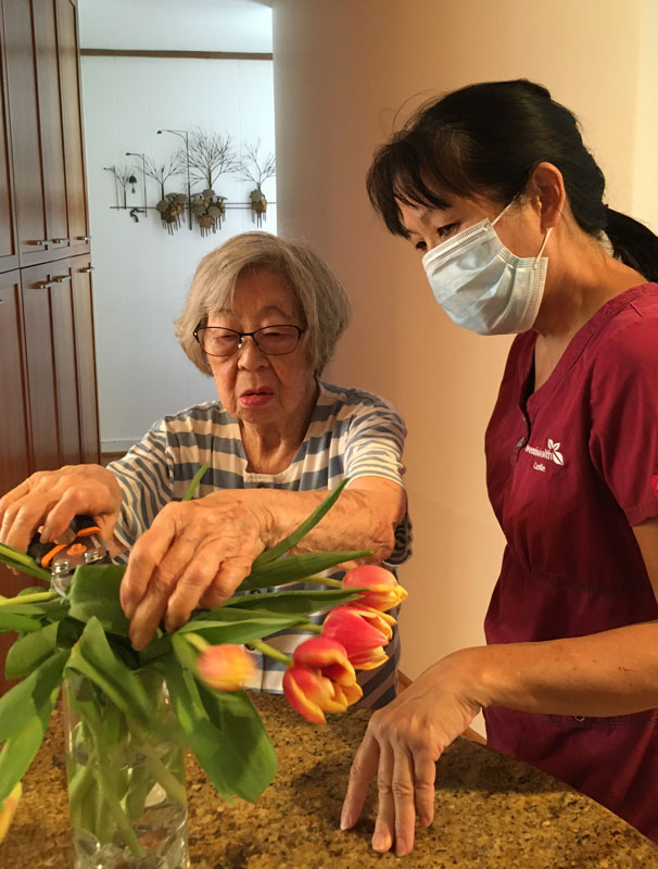 woman cutting flowers with nurse